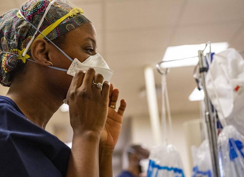 Un trabajador médico se pone una mascarilla antes de entrar en una sala de presión negativa con un paciente de Covid-19 en la sala de cuidados intensivos.