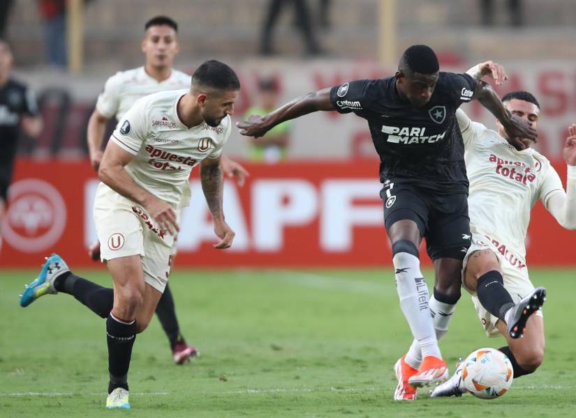 Rodrigo Ureña (i) y Matías Di Benedetto (i) de Universitario disputan el balón con Luiz André Rosa de Botafogo