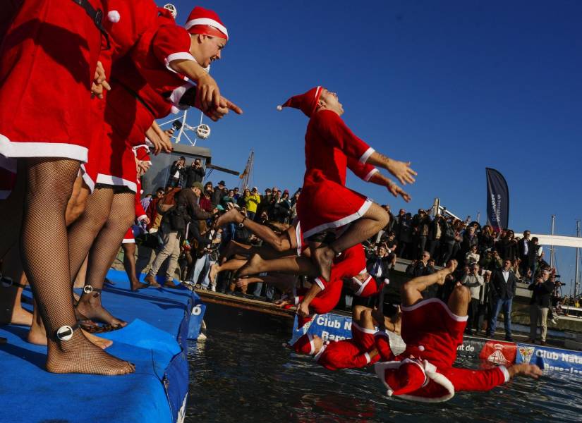 Varios participantes se lanzan este lunes 25 de diciembre al agua durante la celebración de la 114 edición de la Copa Nadal en el Puerto de Barcelona. Tienen 424 personas inscritas.