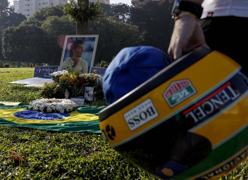 Un seguidor del automovilista brasileño Ayrton Senna sostiene un casco frente a la tumba del piloto en Sao Paulo, este miércoles, cuando se conmemoran tres décadas de su fallecimiento.