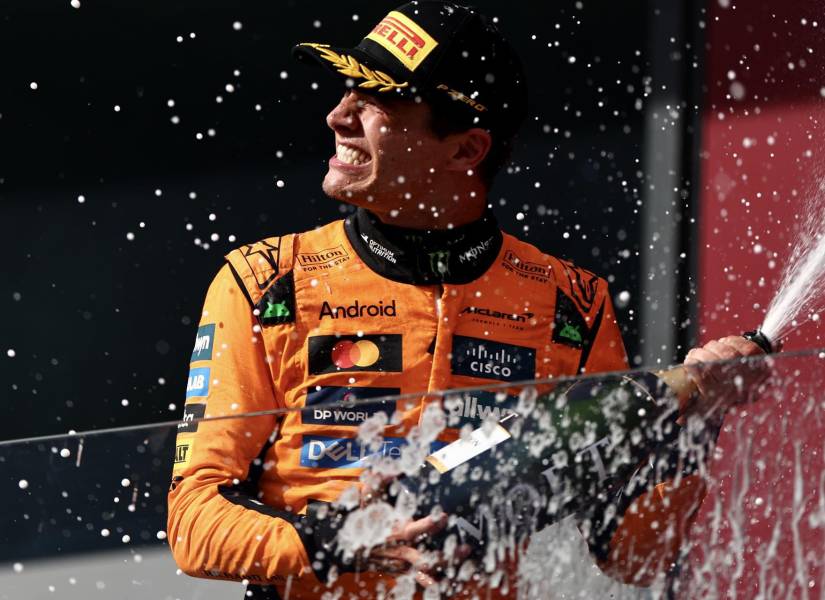 El piloto británico de McLaren, Lando Norris, celebra en el podio rociando champán tras obtener el primer lugar en el Gran Premio de Hungría de Fórmula 1