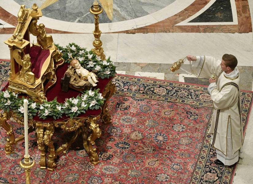 La imagen proporcionada muestra a un sacerdote bendiciendo a un niño Jesús mientras el Papa Francisco dirige la Misa de Navidad de Medianoche en la Solemnidad de la Natividad del Señor en la Basílica de San Pedro en el Vaticano, el 24 de diciembre de 2023.