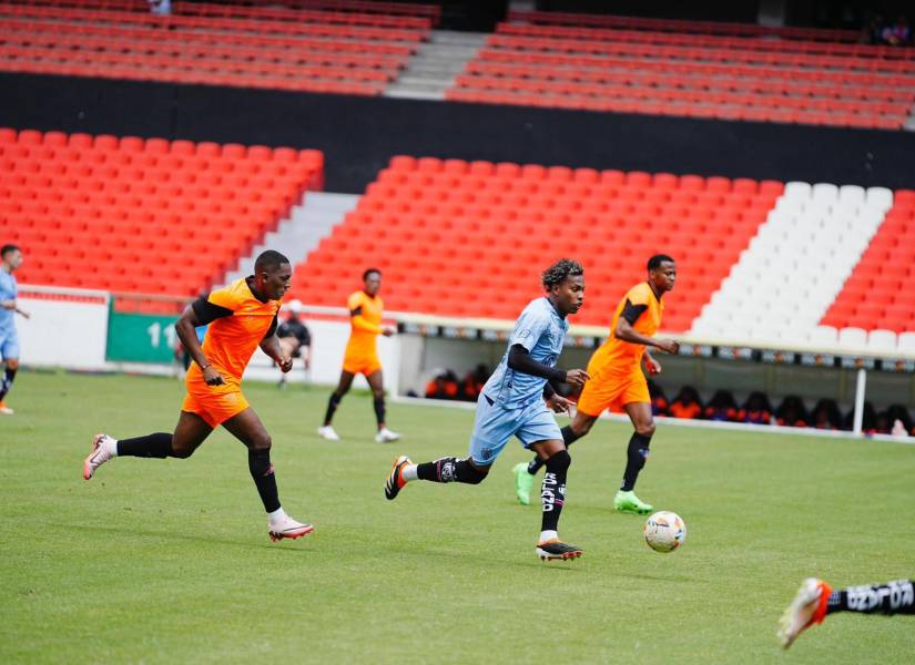Joao Ortiz conduce el balón ante la marca de los jugadores de Liga de Quito