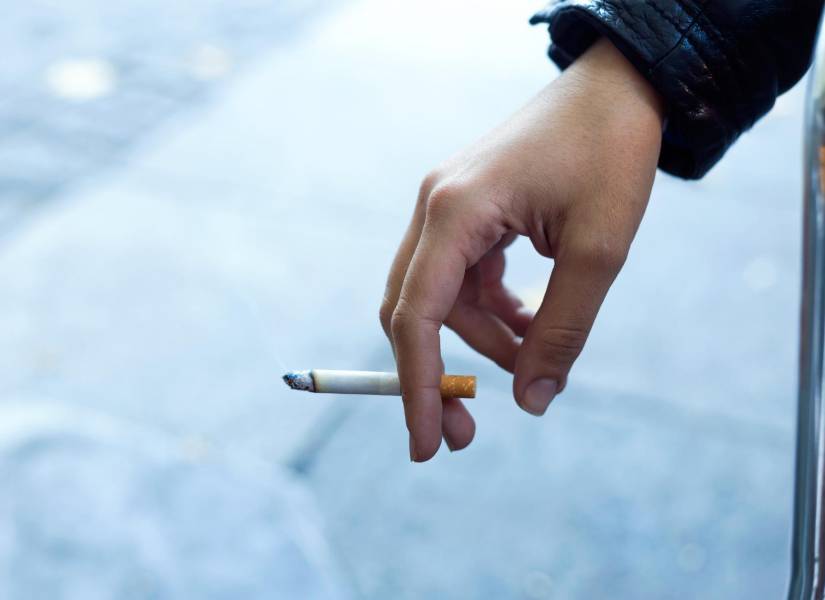 Mujer sosteniendo un cigarro.