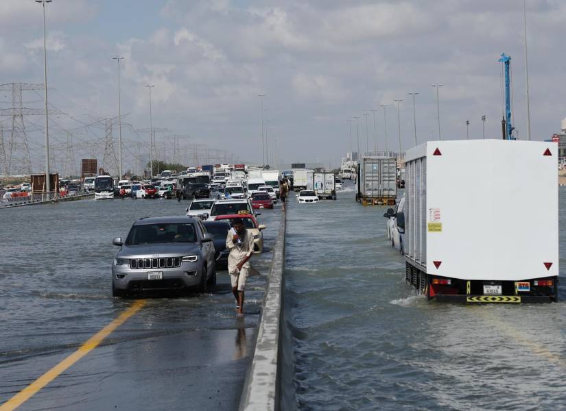 Vehículos manejando en calles inundadas.