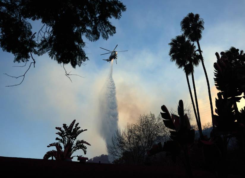 Un helicóptero lanza agua sobre el incendio forestal de Palisades, en Los Ángeles, California (EE.UU.). EFE/ALLISON DINNER