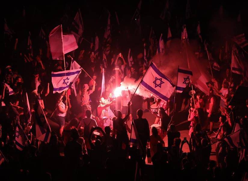 Manifestantes con bengalas en las calles de Tel Aviv, Israel.