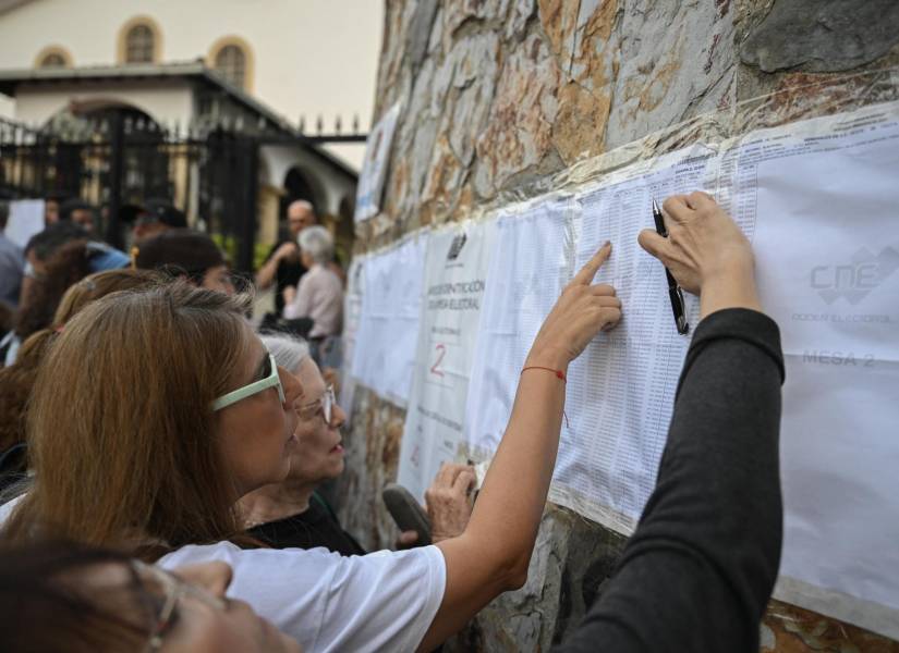 La gente revisa el censo electoral afuera de la escuela Santo Tomás de Villanueva donde se espera que vote el candidato presidencial Edmundo González Urrutia durante las elecciones presidenciales venezolanas, en Caracas el 28 de julio de 2024.