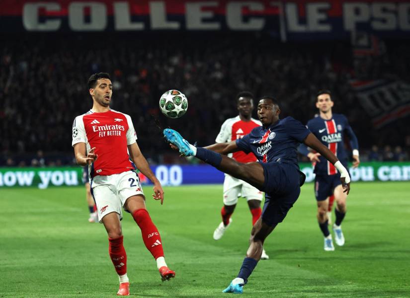 El defensa del PSG, Willian Pacho, despeja un balón contra el Arsenal por la Champions League