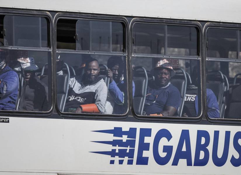 Algunos de los 260 empleados que habían quedado atrapados bajo tierra se sientan dentro de un autobús al salir del subpozo Kloof 7 de Sibanye Stillwater en Westonaria, Sudáfrica, el 23 de mayo de 2025.