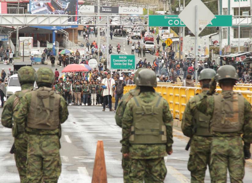 Soldados se forman frente a indígenas que protestan para exigir una solución al derribo de dos puentes comunales fronterizos por parte del Ejército ecuatoriano.