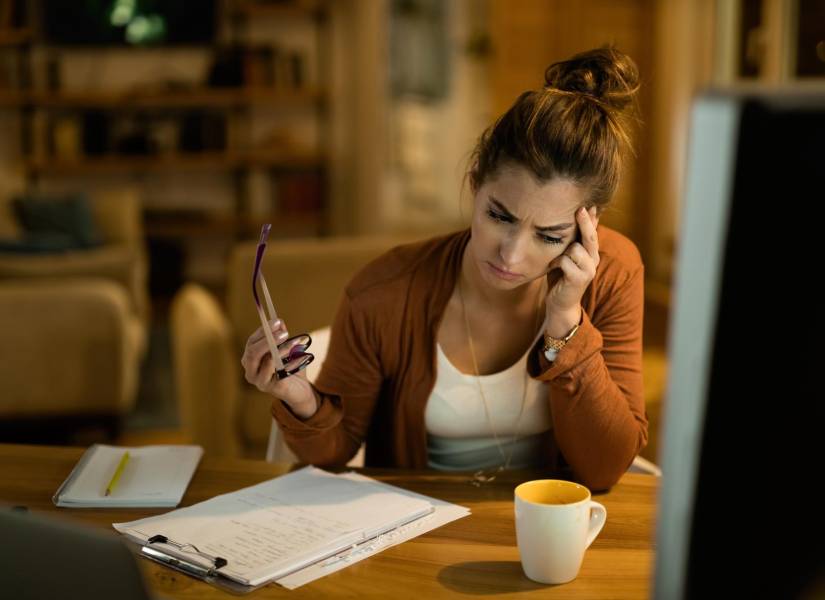 Mujer preocupada revisando cuentas.