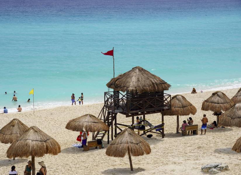 Una bandera roja advierte de la llegada del huracán Milton en una playa de Cancún, México.