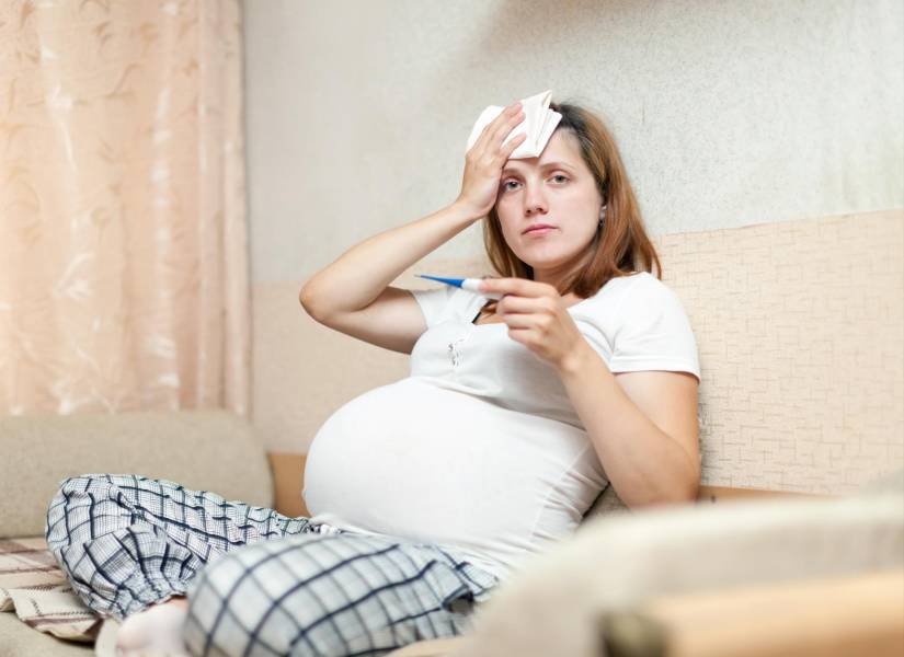 Mujer embarazada con termómetro