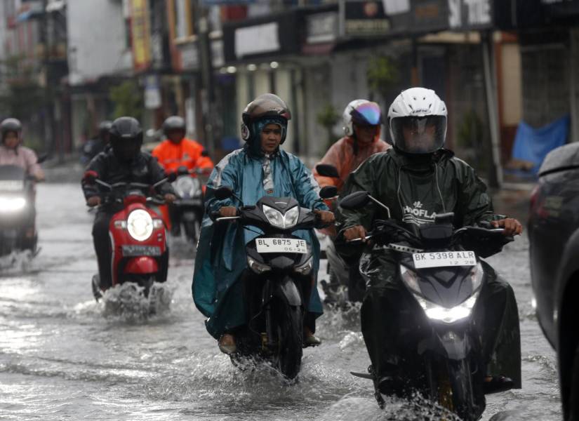 Motociclistas circulan entre las aguas inundadas por las fuertes lluvias en la zona de Banda Aceh, Indonesia, este jueves 27 de noviembre.