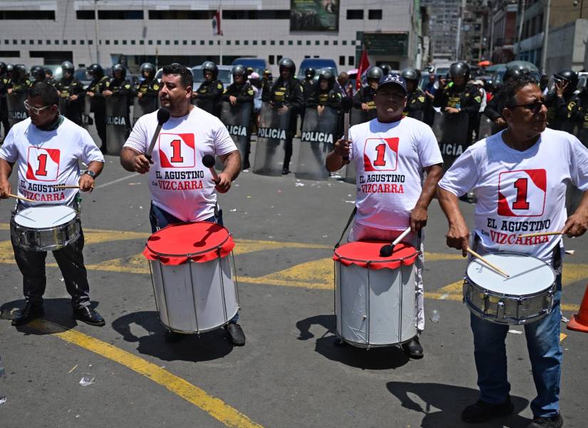 Partidarios del expresidente peruano (2018-2020) Martín Vizcarra, tocan tambores frente a un cordón policial frente al Palacio de Justicia Carlos Zavala Loayza en Lima, el 26 de noviembre de 2025.