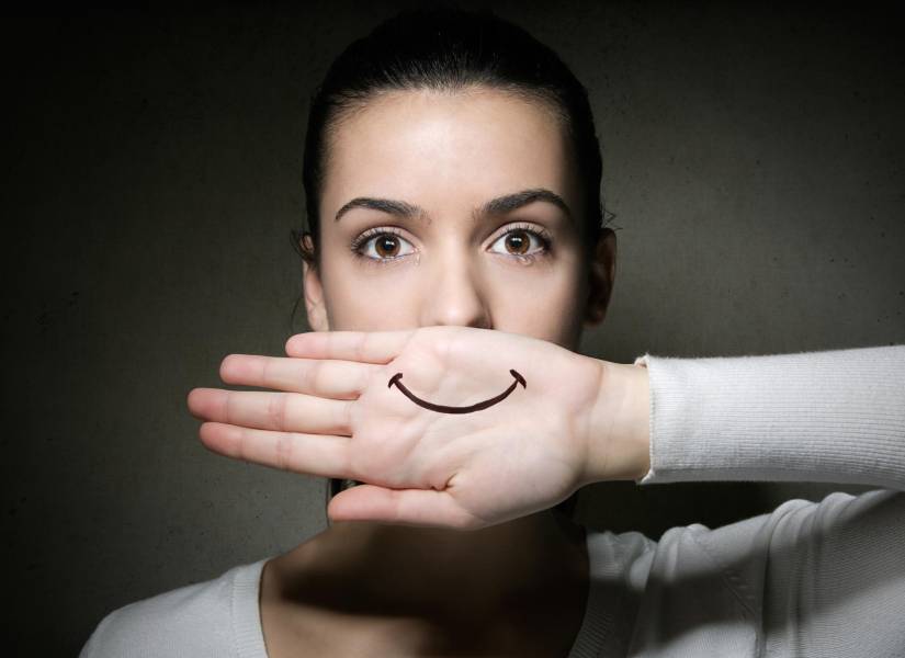 Mujer llorando cubriendo con su mano la boca con sonrisa
