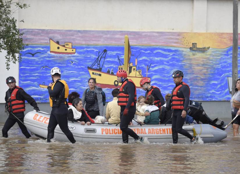 Personas son transportadas en un bote policial a través de aguas inundadas al día siguiente de una fuerte tormenta en Bahía Blanca.