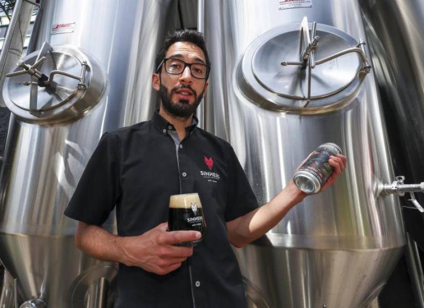 Andrés Bermeo, sirve una muestra de la cerveza premiada recientemente en los World Beer Awards.