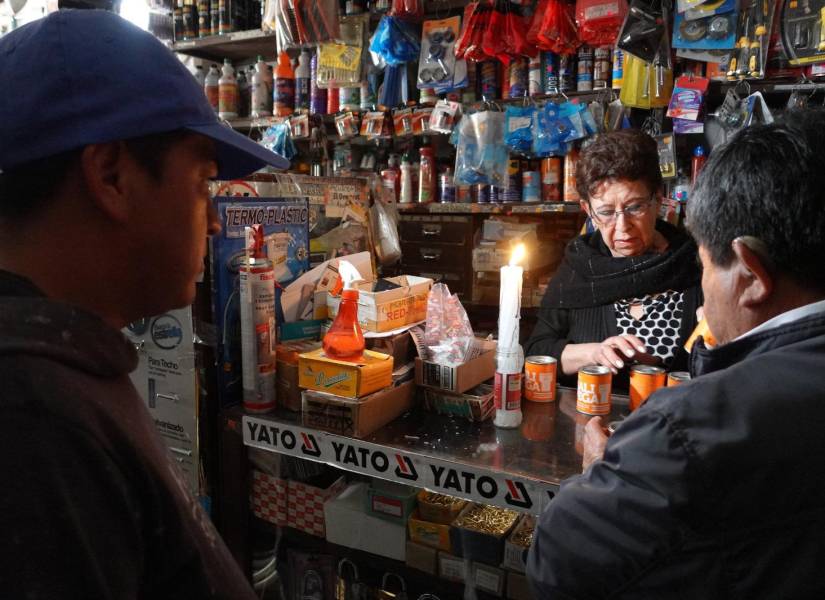 Una ferretería en Cuenca atiende con velas por los cortes de luz.