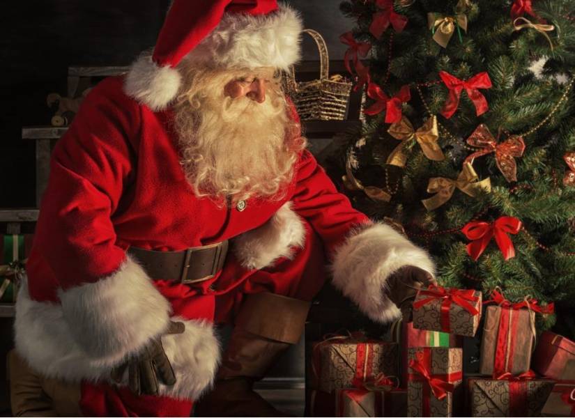 Papá Noel coloca los regalos debajo del árbol de Navidad
