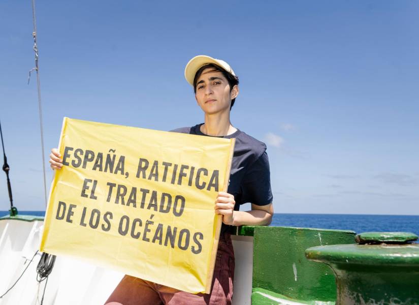 Alba Flores con un cartel en el que pide a España ratificar el Tratado Global de los Océanos, durante una expedición científica de la organización ecologista a las Islas Galápagos.