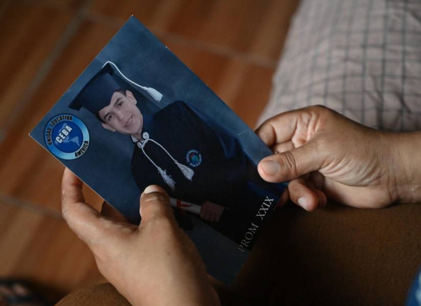 Laura Ipanaqué Baquerizo, madre de Javier Vega Ipanaqué, quien falleció durante un operativo militar durante el conflicto armado interno en Ecuador, sostiene una foto de su hijo durante una entrevista con AFP en Guayaquil, Ecuador, el 21 de febrero de 2024.