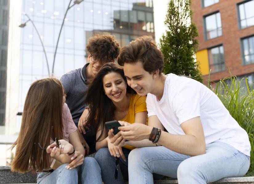 Amigos al aire libre en la ciudad mirando smartphone