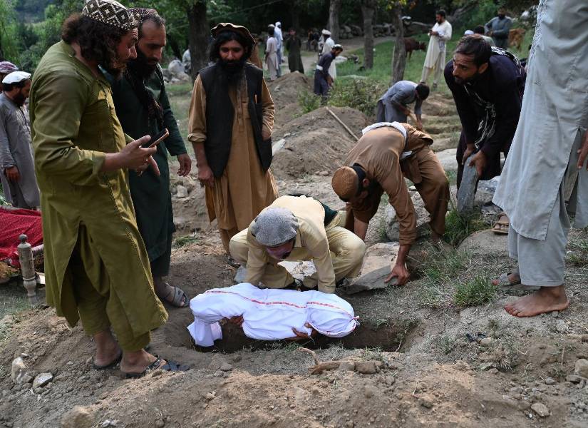 Las víctimas del terremoto del domingo son sepultadas por sus familiares.
