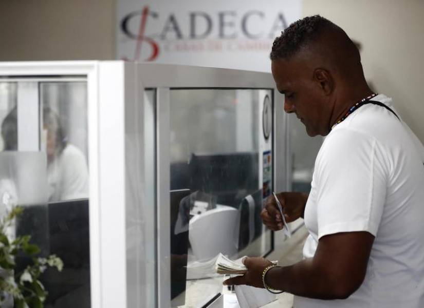 Un hombre cambia dinero en Cuba, donde hay la limitante de 100 dólares por día.