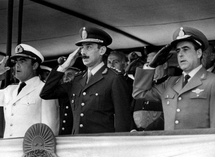 El almirante Emilio Eduardo Massera (izq.), el presidente de Argentina, Jorge Rafael Videla (centro), y el comandante en jefe Orlando Agosti (der.) se encuentran en la tribuna, en septiembre de 1977, durante una ceremonia militar.