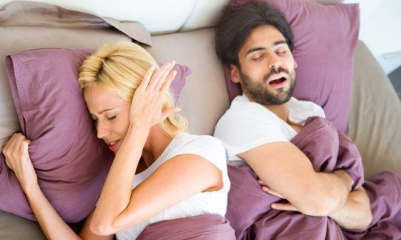 Una mujer sin poder dormir por los ronquidos de su pareja.