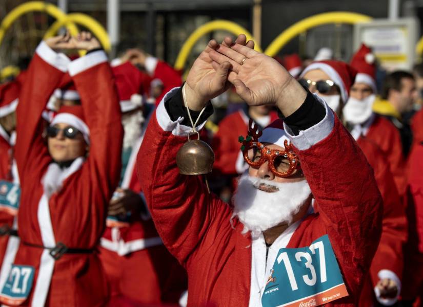Personas vestidas como Papá Noel calentando antes de la tradicional carrera de Papá Noel en Skopje, República de Macedonia del Norte, el 24 de diciembre de 2023.