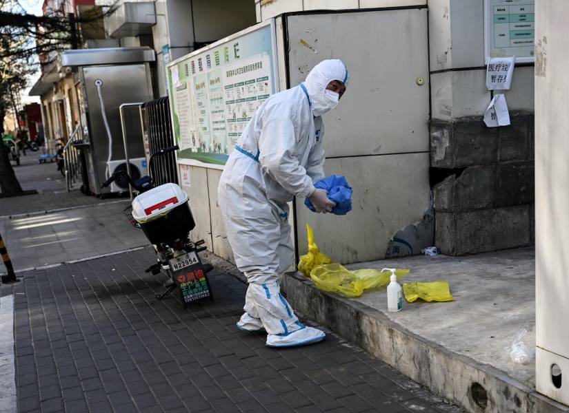 Un trabajador con equipo de protección individual (EPI) en medio de la pandemia de Covid-19 es visto en una calle de Beijing el 11 de diciembre de 2022.