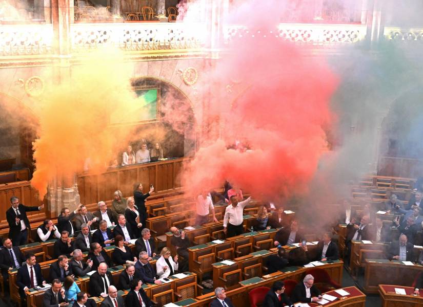 Miembros del partido centrista Movimiento Momentum queman bengalas en protesta antes de la votación sobre un proyecto de ley que busca prohibir la marcha anual del Orgullo el 18 de marzo de 2025.