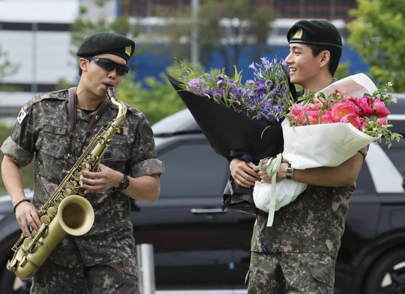 RM toca el saxofón junto a su compañero de banda V mientras tienen un encuentro con fans en Chuncheon, Corea del Sur.