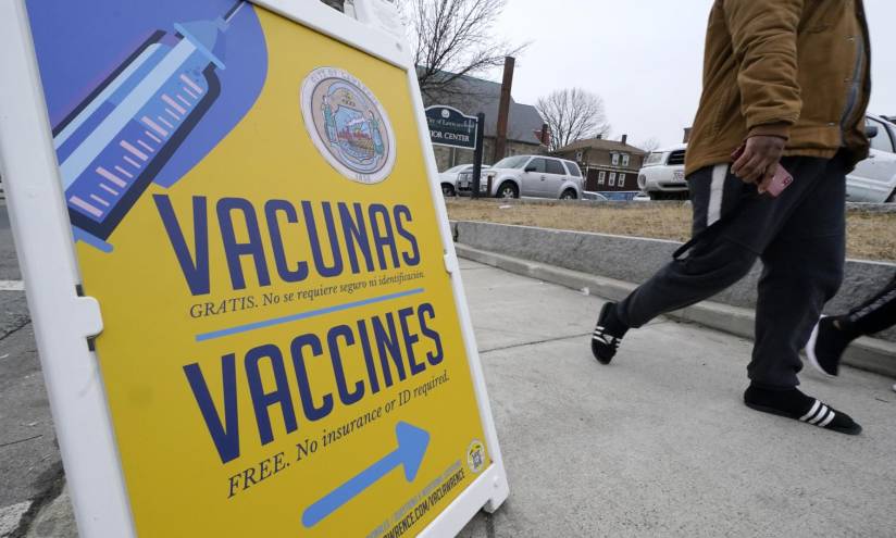 Un letrero en español e inglés indica el rumbo a una clínica de vacunación contra COVID-19 en Lawrence, Massachusetts.