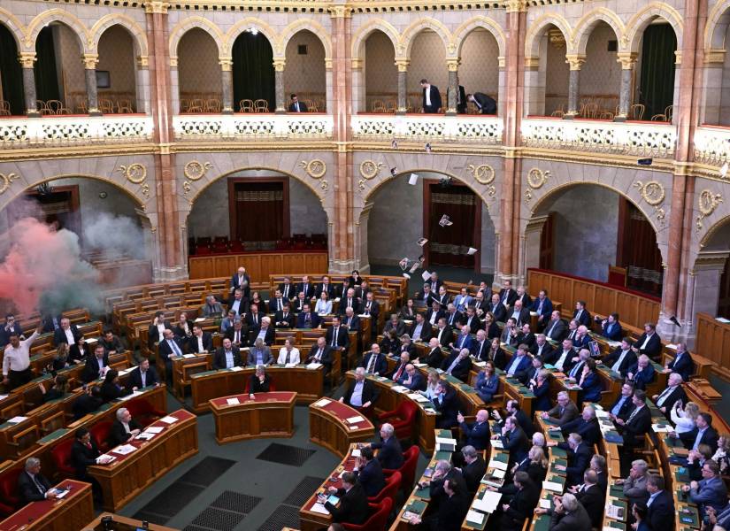 Miembros del partido centrista Movimiento Momentum queman bengalas en protesta antes de la votación sobre un proyecto de ley que busca prohibir la marcha anual del Orgullo el 18 de marzo de 2025.