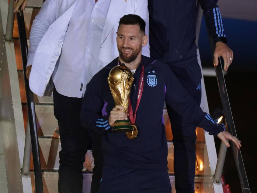 AMDEP9828. EZEIZA (ARGENTINA), 19/12/2022.- Lionel Messi de la selección argentina de fútbol desciende con el trofeo del Mundial de Fútbol Qatar 2022 a su llegada hoy, al Aeropuerto Internacional de Ezeiza a unos 22km de Buenos Aires (Argentina). EFE/ Raúl Martínez