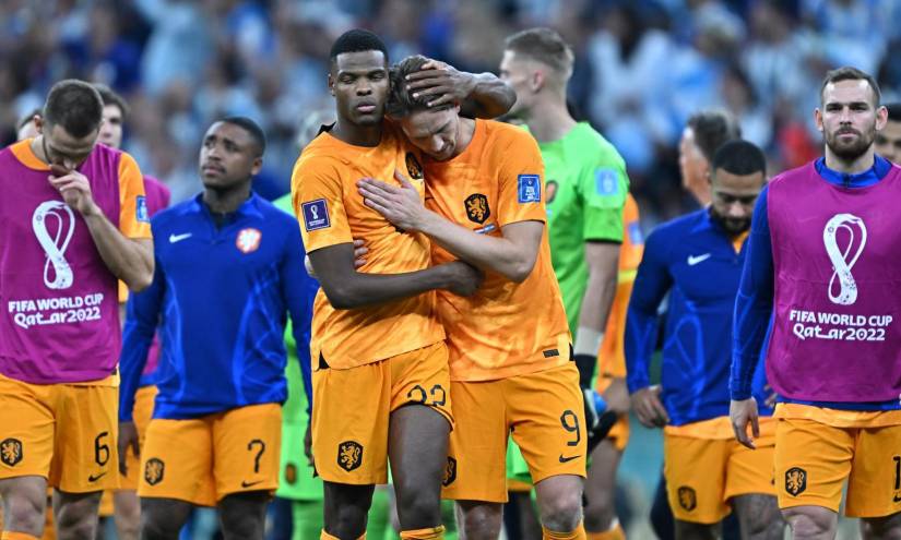 Jugadores de Países Bajos salen tristes de la cancha tras caer en penales ante Argentina.