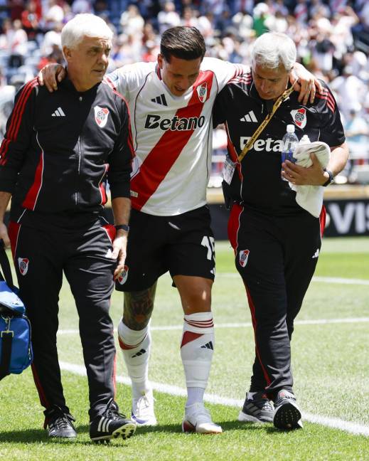 El delantero del River Plate, Sebastián Driussi (C), es ayudado a salir del campo tras lesionarse en el partido contra el Urawa Red Diamonds.