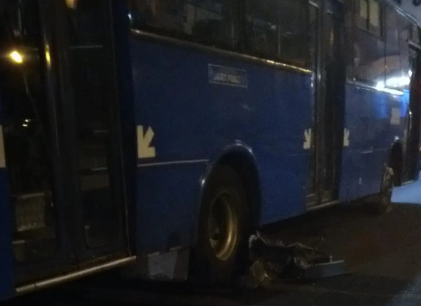 Los restos de la motocicleta y el conductor quedaron bajo el bus.