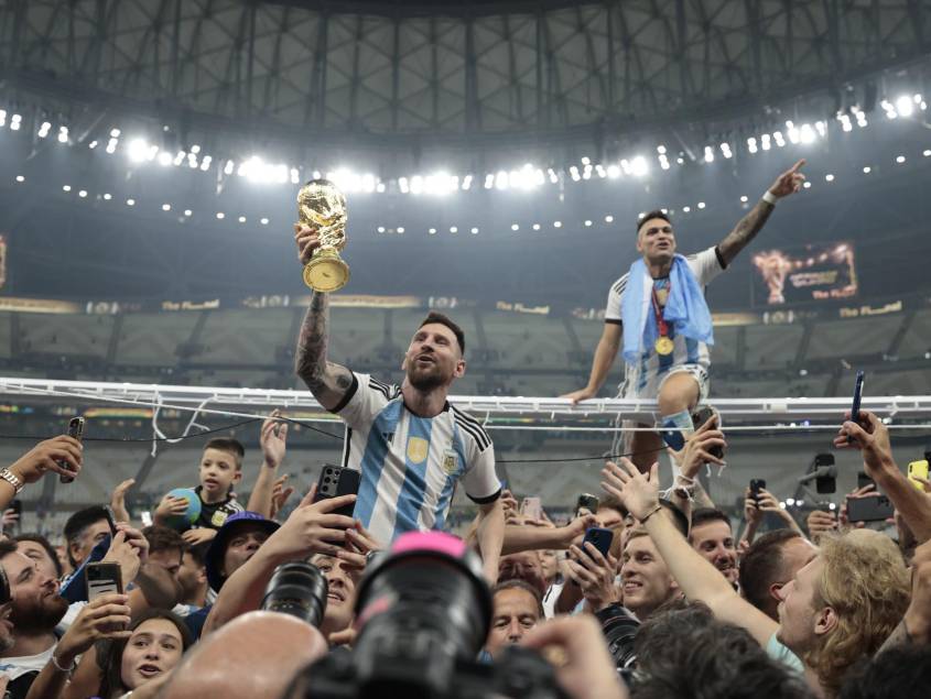 Lionel Messi, alzado en hombros y con el trofeo en la mano, celebra la conquista del Mundial. EFE/ Juan Ignacio Roncoroni