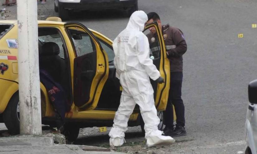 Imagen de agentes de Criminalística revisando una escena del crimen en un taxi de Portoviejo, donde fue asesinado un adolescente el pasado 2 de julio del 2023.