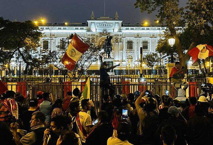 Manifestantes con banderas a las afueras del Palacio de Gobierno en Lima, Perú.